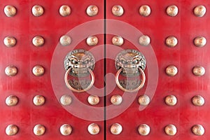 Wood Chinese door painted with red color with traditional bronze chinese lion head knockers.wood door entrance of chinese temple