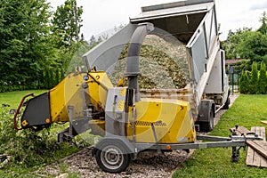 Wood chipper at the arborist`s dump truck performing chip branching
