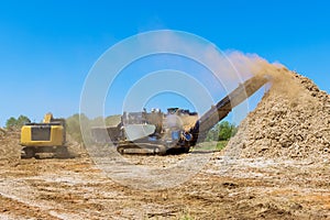 This wood chipper machine has a mulch conveyor as well as a conveyor for shredding roots.