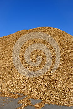 Wood chips pile at an industrial storage place