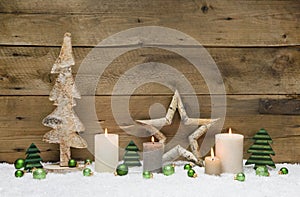 Wood Christmas decoration with green balls, candles and stars on