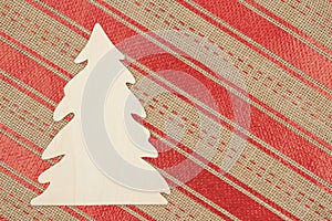 Wood Christmas tree with red and beige sparkle ribbon weave textured background