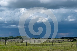 Wood Corral with approaching storm clouds, Saskatchewan, Canada.