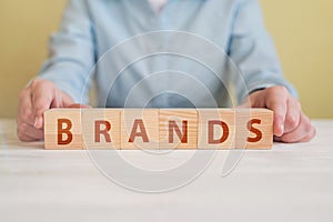 Wood cube block with word BRAND on wooden table