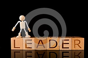 Wood cube block with word â€œLEADERâ€ and Wooden Stick Figure standing