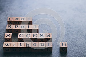 Wood cube letter word of Cant Spell SUCCESS without U. Idea of motivation and inspiration in business vision and corporate