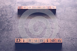 Wood cube letter word of Disunion and Teamwork. Idea of motivation or inspiration in business vision and corporate management