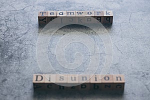 Wood cube letter word of Disunion and Teamwork. Idea of motivation or inspiration in business vision and corporate management