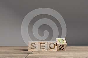Wood cubes with acronym `SEO` - `Search Engine Optimisation` on a beautiful wooden table, studio background. Business concept