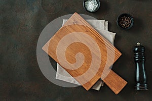 Wood cutting board over towel on stone kitchen table