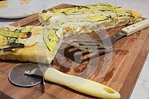 Wood cutting board with pizza and knife