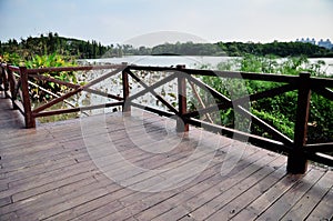 Wood deck by the lake in park garden structure