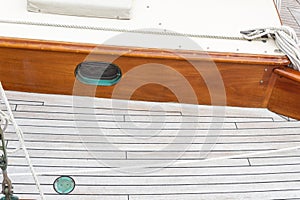 Wood deck and porthole of an old wood sailboat, verdigris patina, copy space