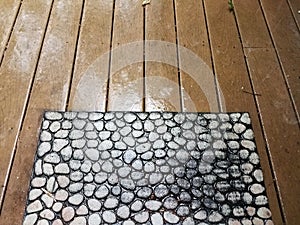 Wood deck with water on it and welcome mat