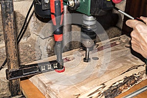 Wood drilling machine working on plank and producing chips