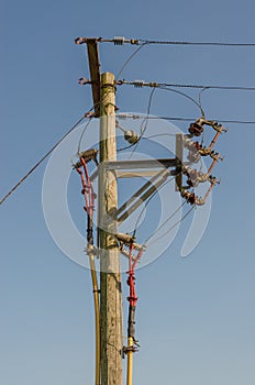 A wood electricity pylon with cabling and insulators