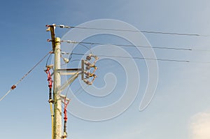 A wood electricity pylon with cabling and insulators