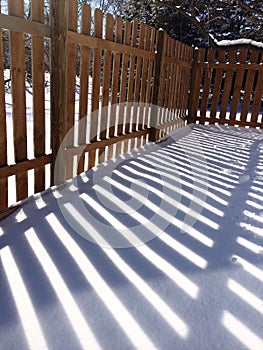 Wood fence shadow in snow