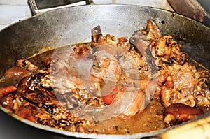 Chicken meat with pig`s feet, pout pepper cooking in the wood oven photo