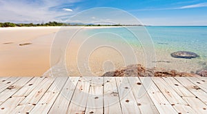 Wood floor on blur beautiful sand and sea scenery background.