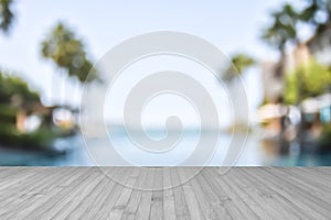 Wood floor with blur summer background tropical resort hotel with swimming pool water and palm tree