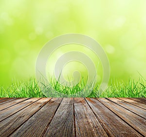 Wood floor with green bokeh and Fresh spring green grass and sunlight