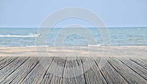 Wood floor on sand beach and tropical sea with blur jet ski solf focus