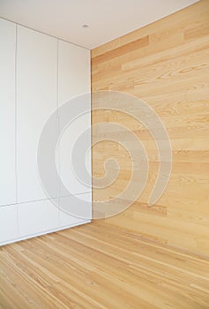 Wood Flooring with modern wooden wall as interior room design and white hidden wardrobe.