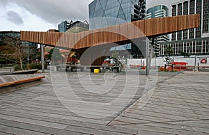 Modern wood North Kumutoto Pavilion with strips on folded plates and steel posts on decked square in Wellington CBD, New Zealand