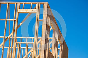 wood framing structure at new property development site new home currently under construction against blue sky