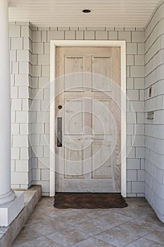 Wood front door of home with raw finish in daytime