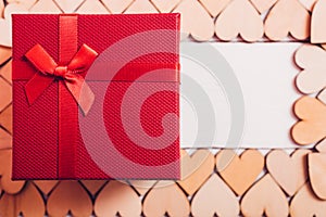 Wood hearts and red gift box on white wooden background