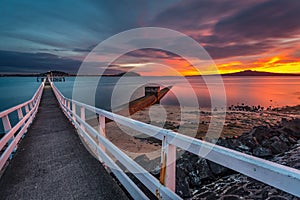 Wood jetty crossing a concrete tunnel in morning twilight