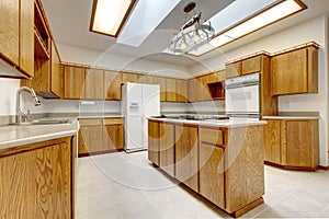 Wood kitchen with island without windows with bright light.