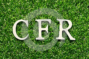 Wood letter in word CFR abbreviation Cost and freight on green grass background