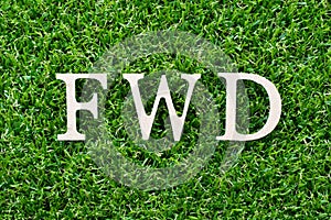 Wood letter in word FWD Abbreviation of forward on green grass background photo