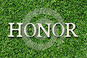 Wood letter in word honor on green grass background