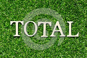 Wood letter in word total on green grass background