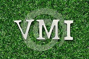 Wood letter in word VMI abbreviation of vendor managed inventory on gree grass background