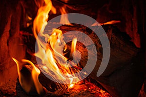 Wood log burning in the chimenea. Fire wood, coal and amber ash closeup. photo