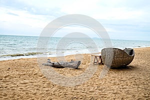 Wood log and wicker chair on beach