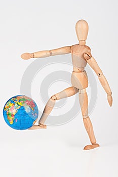 Wood mannequin kick a world globe in disrespect isolated