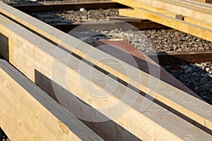 Wood material on the building site at November, close up, selective focus. Wooden boards stacked in rows and lie on the ground.