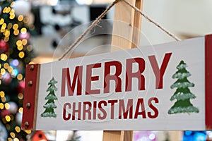 Wood Merry Christmas sign hanging on the timber column