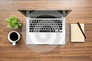 Wood office desk table with laptop computer, cup of coffee and office supplies. Top view, flat lay image