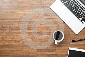 Wood office desk table with laptop computer, cup of coffee and supplies. Top view with copy space, flat lay