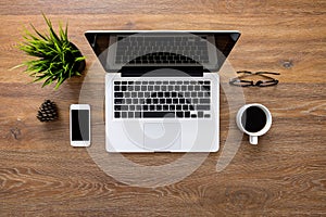 Wood office desk table with laptop computer and office supplies. Top view with copy space, flat lay