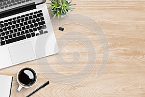 Wood office desk table with laptop, cup of coffee and office supplies. Top view with copy space, flat lay