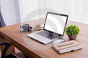 Wood office table with blank screen on laptop at home, copy space, top table