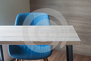 wood office table with blue chair on wood wall background texture at working room. view form front office table.